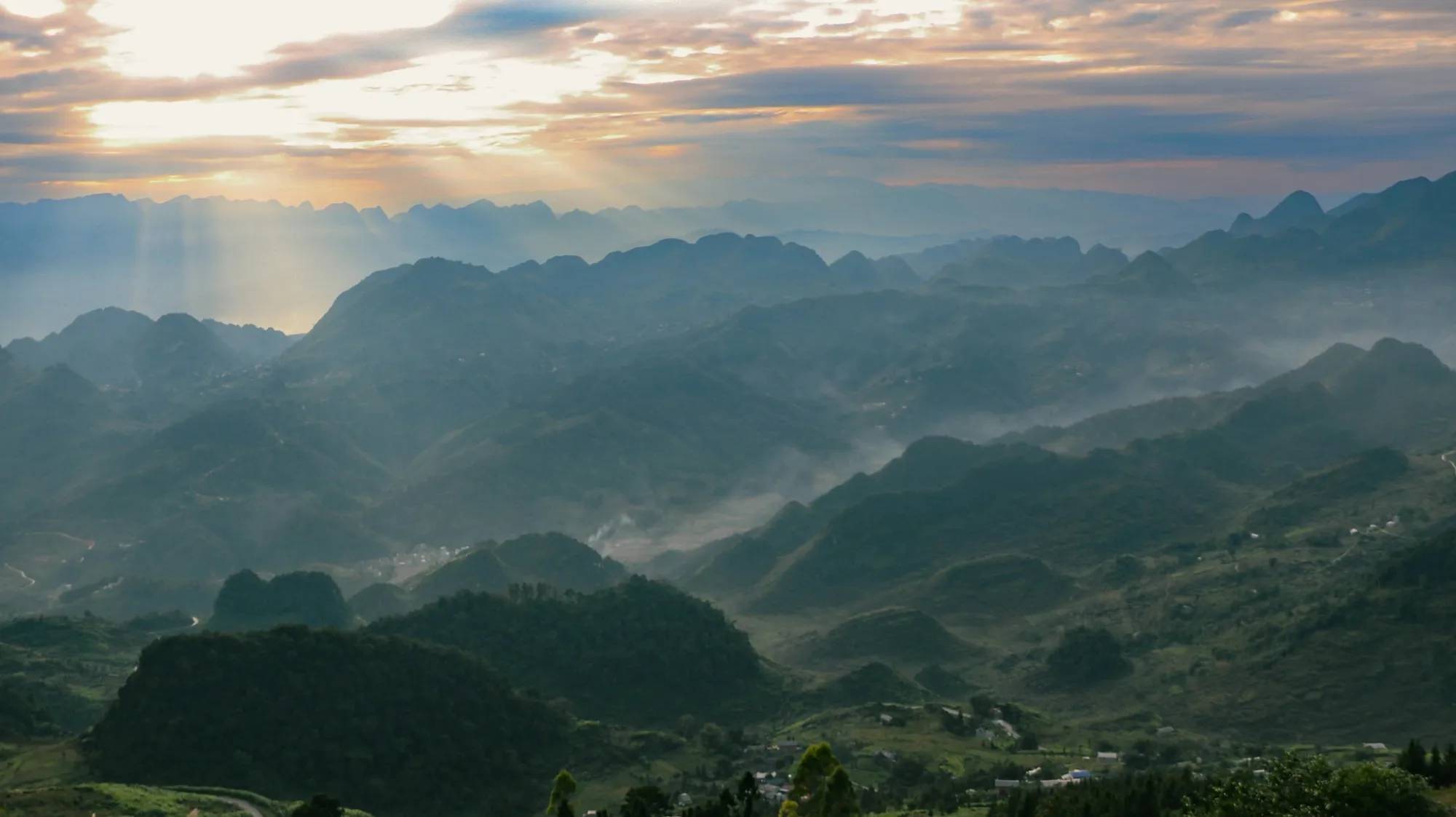 Golden light over misty mountain ridges on the Ha Giang Loop